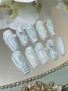 这款美甲贴纸套装包含10张长款棺材形手工美甲贴纸，设计可爱甜美。Y2K风格的手绘渐变腮红底色上点缀着四角星、棋盘格纹、波点、彩色水钻、3D立体蝴蝶结、猫爪印和樱桃图案。整套美甲贴纸散发着优雅精致的气息。 - 綠色 - 查看 13