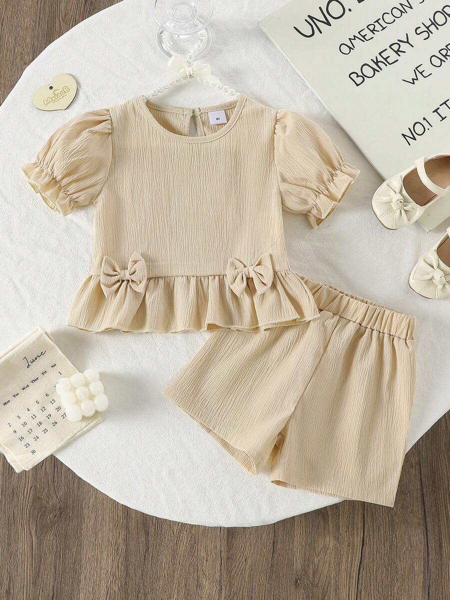 Set de 2 piezas de top de manga corta y shorts de unicolor suave y cómodo con decoración de lazo en tela arrugada para niñas, adecuado para uso al aire libre, primavera/verano - Albaricoque - Ver 1