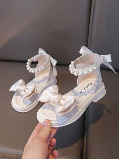 Sandalias de niña con decoración de lazo, adornadas con perlas y suela gruesa, de estilo princesa dulce, elegantes para salidas de verano