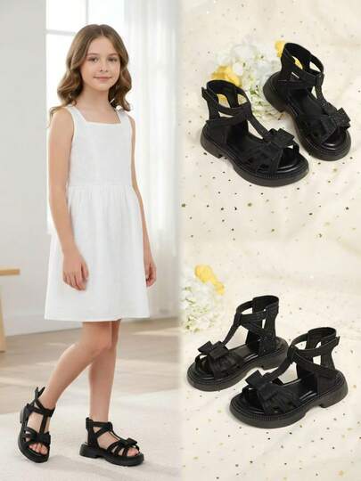 1双黑色加大码女童亮片铆钉皮革蝴蝶结交叉绑带罗马凉鞋，经典双扣圆头平底防滑时尚可爱公主风沙滩休闲鞋，适合2026年春夏