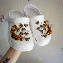 16 件豹纹爱心吊坠 + 琥珀链鞋扣 | 木屐装饰配件 | 时尚 DIY 鞋履装饰套装。豹纹爱心吊坠融合了野性与甜美，琥珀链扣则拥有半透明质感和复古气息。只需简单的夹子和插扣即可轻松安装，让您的普通木屐瞬间变身吸睛街头风单品，完美适用于日常出行或度假造型！