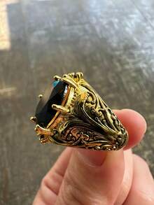 这款戒指风格华丽独特，极具个性。戒身采用黑金双色设计，金色部分饰以精美的镂空花卉和卷草纹饰。线条流畅，层次分明，尽显古典宫廷风格的精致奢华。适合追求独特品味和复古美学的佩戴者。 - 黑色 - 查看 4