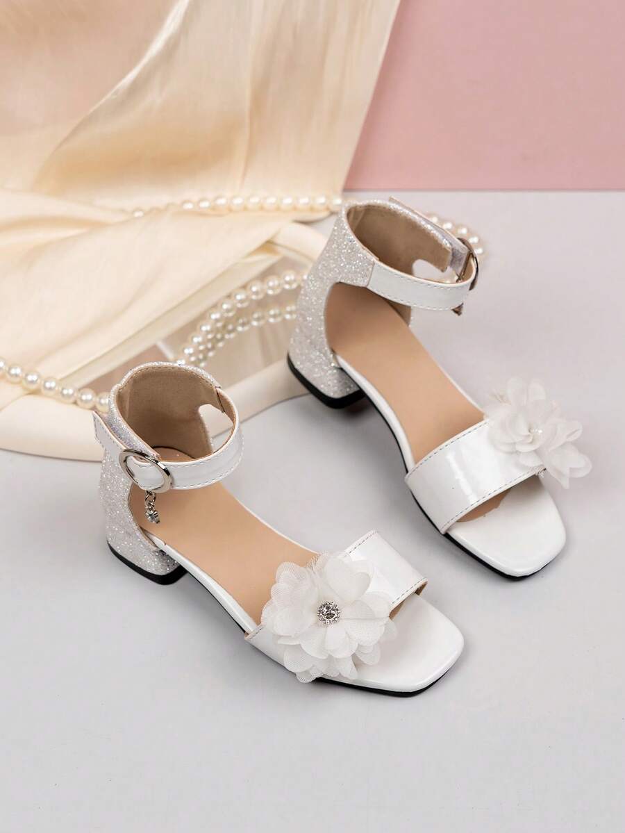 一双儿童时尚高跟凉鞋,银色亮片鞋跟,网纱花朵+水钻装饰,白色漆皮,优雅吸睛;踝带饰有小吊坠;方头设计不挤脚;低跟稳固;亮片光滑不刺激皮肤;漆面易于清洁。适合日常搭配连衣裙、参加派对和正式场合,轻松将孩子变成优雅的小公主! - 白色 - 查看 1