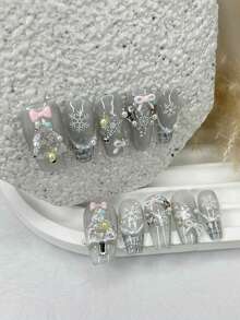 10 piezas de uñas postizas blancas románticas de Navidad hechas a mano con lazos dulces, perlas, diseños de hadas delicadas, copos de nieve y ojos de gato brillantes. Incluye 1 hoja de pegatinas de gelatina y 1 lima de uñas.