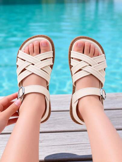 1双儿童凉鞋，2026春夏畅销款，男女童通用，防滑设计，平底防滑，舒适透气，可调节搭扣，圆头设计。简约休闲交叉绑带设计，百搭时尚，米色皮革。适合3-12岁男孩女孩，幼儿、小童、大童均可穿着，适合户外玩耍、日常上学、家庭聚会和逛街等场合。