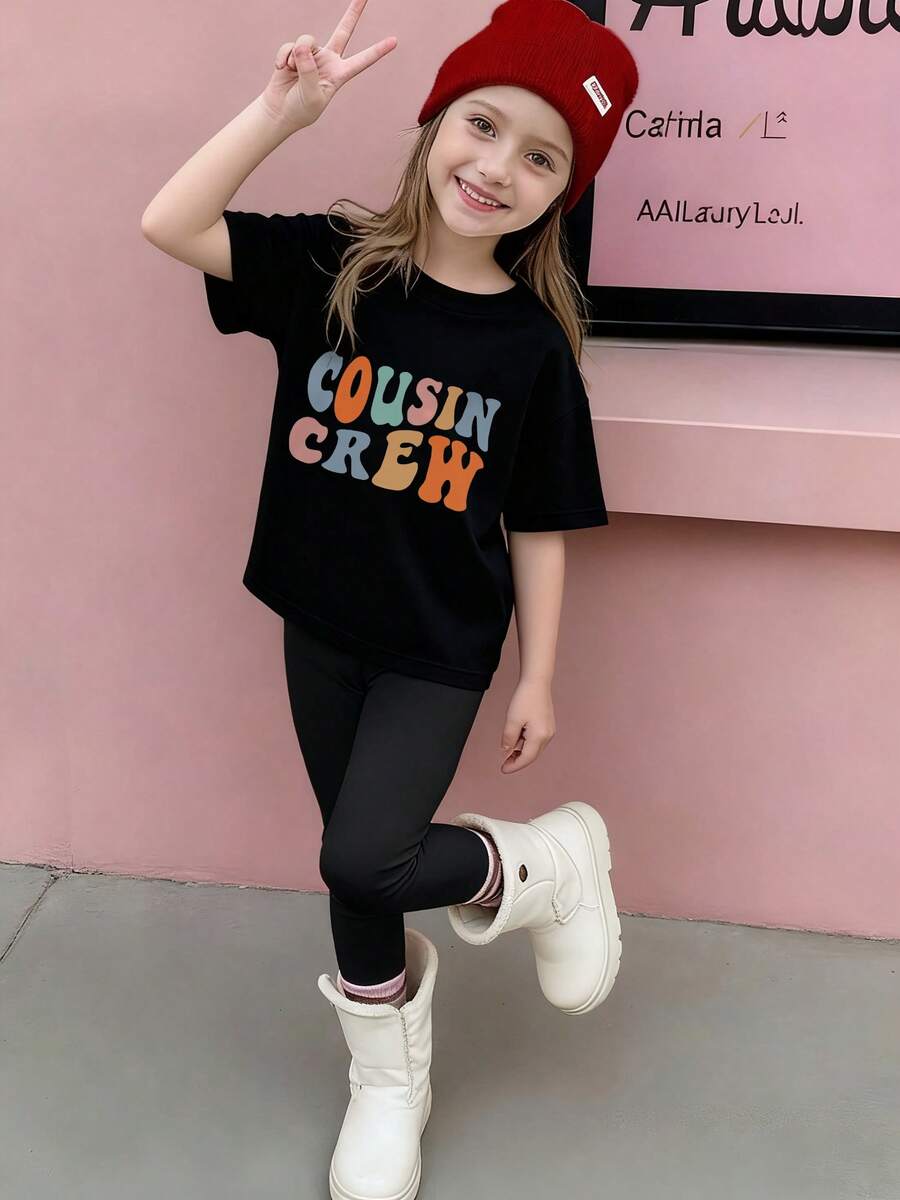 Gorro de punto rojo con etiqueta blanca para ni?a - Camiseta negra 'COUSIN CREW' en colores azul, naranja y verde - Leggings negros cómodos y botas de invierno blancas con rayas rosas - Ropa juvenil alegre y moderna para un estilo único en cualquier ocasión - Negro - Ver 1