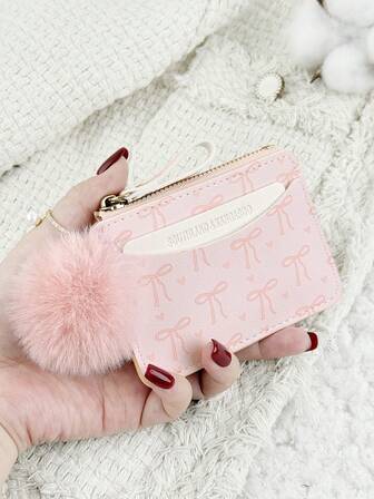 这款带绒球挂饰的粉色蝴蝶结爱心图案拉链小钱包，配有零钱袋，纤薄轻巧，多层设计，可装身份证、现金、信用卡等，简约时尚，适合商务场合，是周年纪念、生日、送礼的理想之选，也适合送给女孩、女士或女性，是学校宿舍和返校季的必备单品。