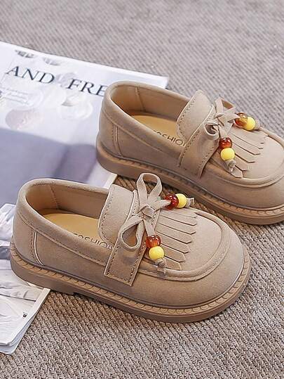 一双休闲复古儿童乐福鞋，鞋面采用PU和天鹅绒拼接，鞋身主体为纯色天鹅绒皮革，饰以蝴蝶结和珍珠，圆头拼接设计简约清新，柔软轻便舒适，魔术贴搭扣方便穿脱，适合儿童日常运动、休闲、玩耍、度假，兼具美观与实用性，四季皆宜。