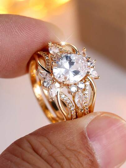 一套两枚镀金叠戴戒指，采用椭圆形镂空设计，镶嵌白色立方氧化锆，现代几何造型，优雅精致，适合女性佩戴。材质低致敏，适合情人节、周年纪念日、生日及日常佩戴。