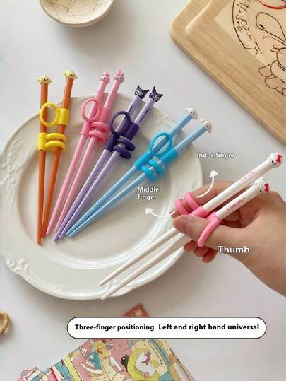  Sanrio Training Chopsticks – pedagogiskt servisset med seriefigurerna Hello Kitty och Kuromi. Detta pedagogiska servis- och lärverktyg är perfekt för familjemåltider, picknick, skolmaterial, matlådetillbehör och ätpinnar, vilket gör det till en perfekt present (officiellt licensierat). Detta söta tecknade bärbara servisset i harts är lämpligt för barn, studenter och utomhusresor.