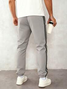 1 قطعة بنطلون رياضي كاجوال للرجال، بناطيل فضفاضة خفيفة الوزن وقابلة للتنفس للركض والأنشطة الخارجية والتنزه والجري والتدريب اللياقة البدنية والشاطئ الصيفي والتنقل، بنطلون قصير مخطط عصري - رمادي فاتح - مشاهدة 2