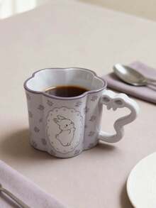 1个陶瓷马克杯，饰有精致的花卉边饰和可爱的动物图案，包括兔子/猫/小狗/熊的设计，花瓣形杯口，以及独特的波浪形心形把手，展现出清新美感，是日常饮水、冲泡咖啡或装饰桌面的理想之选，也是温馨的家居饰品和馈赠佳品。