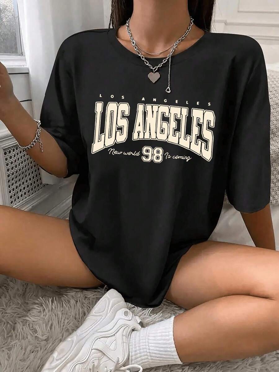 Camiseta de manga corta informal para niña - Estampado gráfico Los Angeles 99, cuello redondo, tejido de punto, color negro con letras amarillas, corte regular, lavable a máquina, cómoda para todas las estaciones, ideal para actividades al aire uso casual, tejido ligeramente elástico. - Negro - Ver 1