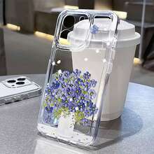 Flores azules en un jarrón blanco sobre fondo blanco. Esta elegante funda es compatible con los modelos  16, 15, 14 Pro Max, 13, 12, 11, XR y XS Plus. Fabricada en silicona TPU, ofrece protección contra golpes y caídas, además de una sensación superior. Es un regalo ideal para familiares, amigos y seres queridos, y una opción perfecta para Navidad. - transparente - Ver 3