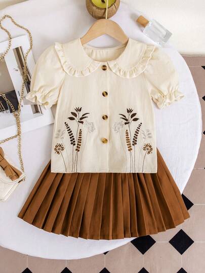 Fräsch outfit med Peter Pan-krage för ung flicka, elfenbensvit blus med Peter Pan-krage + karamellfärgad plisserad kjol, fin blombroderi, puffärmar + plisserad kjol. Lekfull och söt, lämplig för helgpicknick, konstgalleribesök, vårutflykter, ett måste för känsliga tjejer.