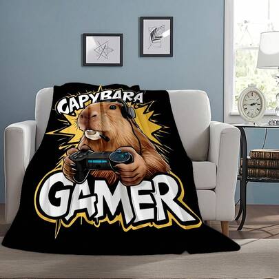 超柔软法兰绒毯，温暖舒适，印有“CAPYBARA GAMER”字样和水豚游戏玩家（戴着耳机，拿着游戏手柄）图案，适合沙发和卧室使用，是游戏玩家和水豚爱好者的绝佳礼物，不易起球。
