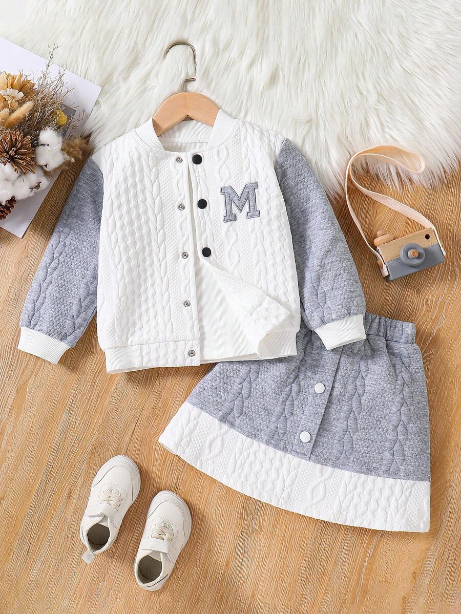 Conjunto feminino estilo motociclista com jaqueta texturizada bordada com a letra M em estilo colorblock e saia com botões em colorblock, ideal para outono/inverno. - Branco - Ver 1