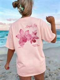 Esta camiseta de cuello redondo con estampado de letras y flores de colores es una opción de moda y versátil para las mujeres en verano. La camiseta gráfica viene en colores blanco y rosa, adecuada para el uso en vacaciones.