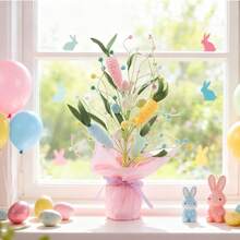 1 Stück/Ostern Kunstblume in Topf, in Kraftpapier verpackt. Lila, gelbe und weiße Blumen mit rosa Filzeiern, orangefarbenen Filzkarotten und grünen Blättern werden verwendet, um die Fensterbank, den Esstisch und die Tischplatte zu dekorieren und eine festliche Atmosphäre zu schaffen. - Niu Nius Osterbaum - Übersicht 12