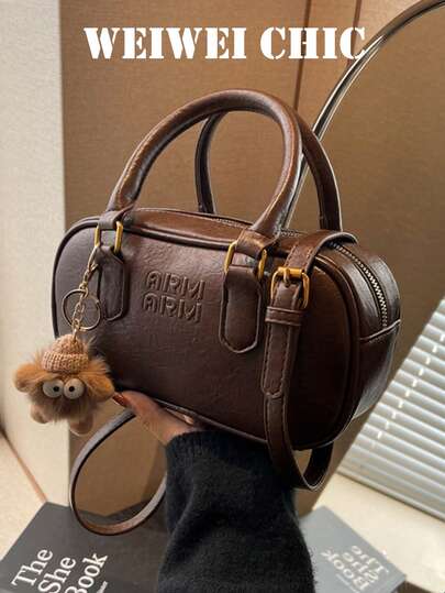 这款女士手提包采用纯色PU材质，饰以字母图案、双提手和吊坠，尽显时尚风格。配有可调节肩带，可手提或肩背。内部空间可容纳口红、钥匙、化妆品和其他日常用品。适合各种场合，包括通勤上班、外出、购物、约会和日常活动。