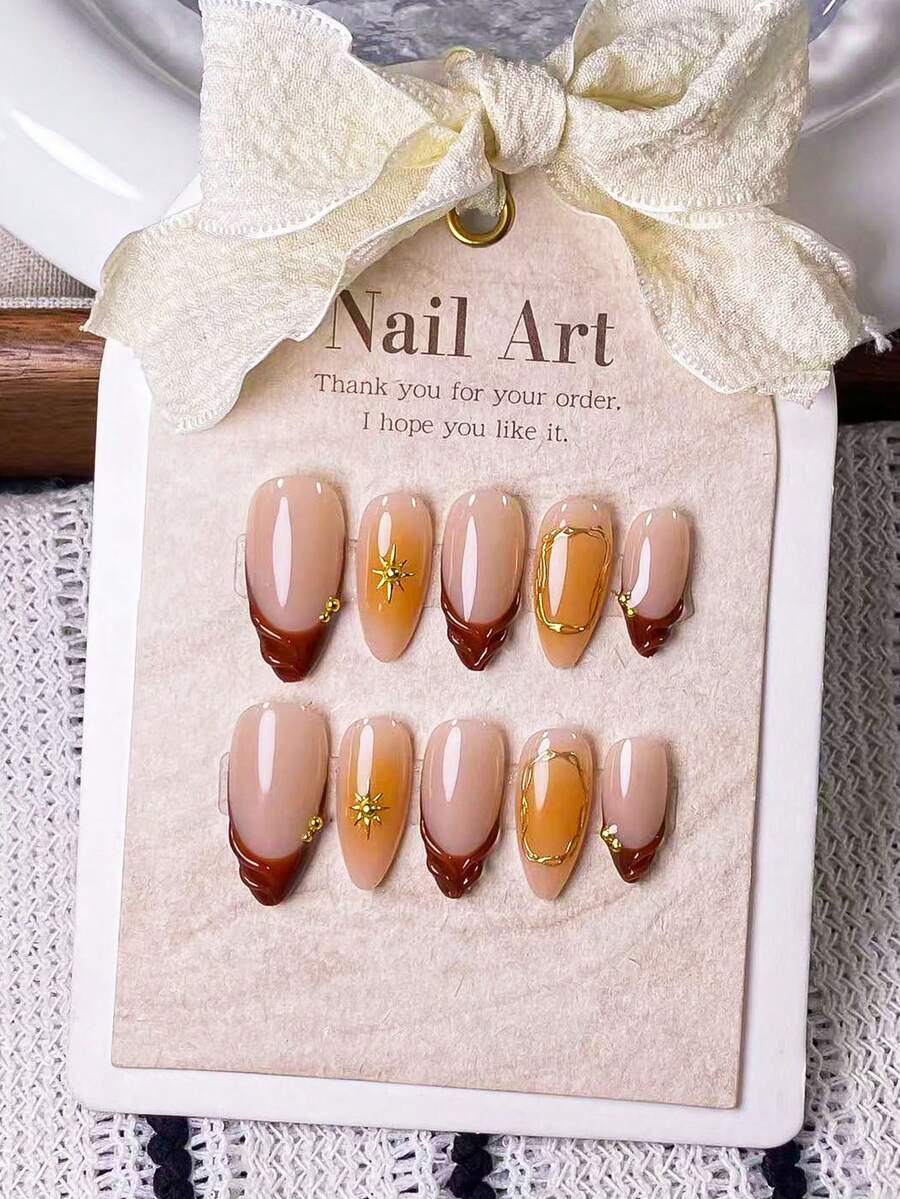 10片手工制作的杏仁形深棕色法式美甲贴纸，带有橙色渐变和星爆图案，并饰以手工制作的橙色渐变和不对称金色圆圈。 - 彩色 - 查看 1