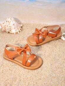 1 Pair Of Girls' Shoes With Caramel Brown Bow Sandals, The Upper Is Made Of Faux Leather Material, With Bow And Cross Strap Design, Exposed Toe Low Top Style, Flat Bottom Lightweight, Casual Retro Style Sandals, Suitable For Park Picnics And Children's Afternoon Tea - Brown - View 1