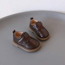 1双儿童鞋，真皮材质，舒适易穿，低帮设计，魔术贴搭扣，平底款式，简约优雅，适合儿童日常穿着，上学、休闲场合皆宜。[请根据实际脚长选择尺码]