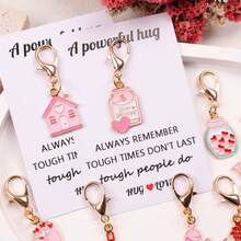 8件套心形主题励志鼓励口袋拥抱礼盒：包含“充满力量的拥抱”卡片，以及独特的粉色吊坠钥匙扣、台灯、茶壶、许愿瓶、漂流瓶、花束和爱心小屋等装饰配件。适合情侣、家庭、生日、节日派对、情人节和母亲节等场合作为礼物。