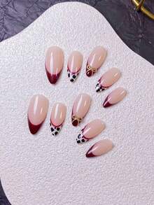 10片手工制作的杏仁形深红色法式美甲贴片，饰以豹纹和蝴蝶结图案，包括手工豹纹法式美甲贴片（红色边缘）和手绘深红色法式美甲贴片（金色蝴蝶结装饰）。 - 彩色 - 查看 6