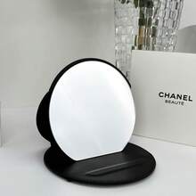 CHANEL 黑色皮革圆形粉盒镜，优雅品牌标志压纹细节，可折叠便携设计，竖式桌面化妆镜，适合作为节日礼物/日常化妆/旅行化妆等多种场合使用。