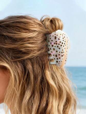 Presilha de cabelo em fibra acetato com estampa de bolinhas e conchas, ideal para decoração de festas e eventos.