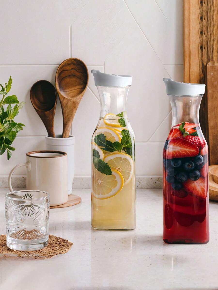 Diese quadratische Wasserflasche ist aus transparentem Kunststoff mit Klapptop-Design und stoßabsorbierender Funktion. Sie eignet sich zum Aufbewahren von Wasser, Eistee, Saft, Limonade, Milch, Cold Brew Kaffee und mosambikanischen Cocktails. Sie ist ein unverzichtbares Küchenutensil für Feiertagsdekorationen und ein hochwertiges Küchenhelfer für Zuhause. - Verschiedenfarbig - Übersicht 1