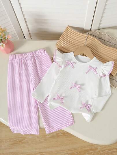Bộ đồ 2 món cho bé gái: Áo dài tay màu trắng có bèo nhún và nơ + Quần ống rộng cạp cao kẻ sọc hồng trắng, kiểu dáng ngọt ngào, thoải mái, dễ mặc hàng ngày, thiết kế nhiều chi tiết nơ, đa năng.