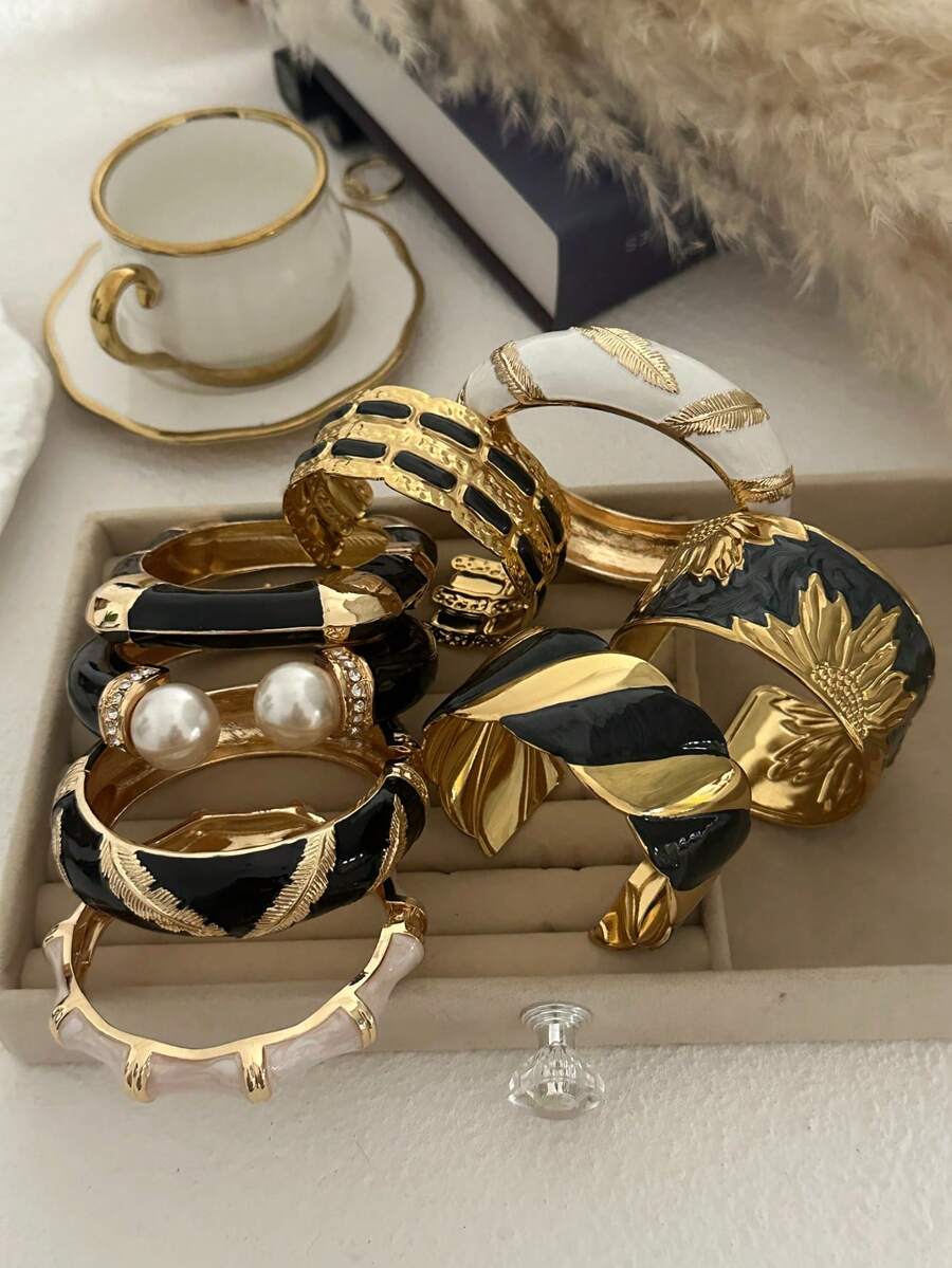 Vòng tay xếp lớp sang trọng màu đen và vàng đính ngọc trai với họa tiết lông vũ dành cho nữ.