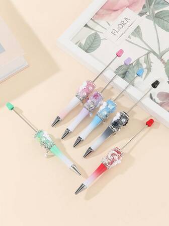 Set med 6 flerfärgade gör-det-själv-pennor med strasspärlor, prydda med Cupid-, ros- och månelement. En begränsad upplaga för Alla hjärtans dag, perfekt för att göra presenter till par, bästa vän-minnen eller perfekta presenter till kvinnor.