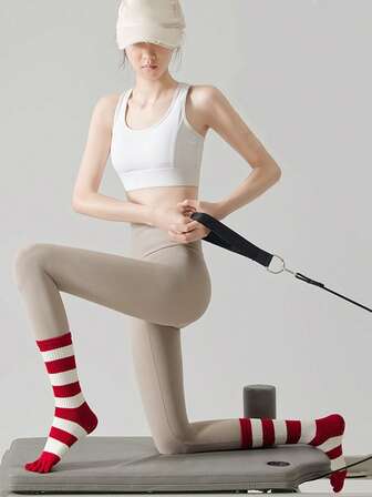 一双红色女士袜子，秋冬季防滑五趾瑜伽袜，适合健身、跑步和有氧运动，中筒长度