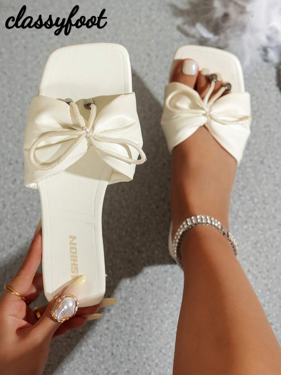 1 đôi dép xăng đan đế bằng chống trượt màu trắng giả da dành cho nữ, kiểu dáng tối giản, có nơ trang trí, rất cần thiết cho mùa hè, mặc hàng ngày và đi nghỉ mát ở bãi biển.