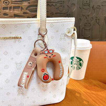 1个水豚U型抱枕钥匙扣，柔软硅胶材质，适合上班族和学生在休息时间缓解压力，小巧尺寸不占桌面空间，可爱的水豚造型可挂在背包侧袋上。