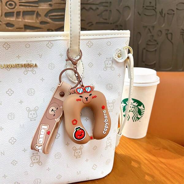 1个水豚U型抱枕钥匙扣，柔软硅胶材质，适合上班族和学生在休息时间缓解压力，小巧尺寸不占桌面空间，可爱的水豚造型可挂在背包侧袋上。