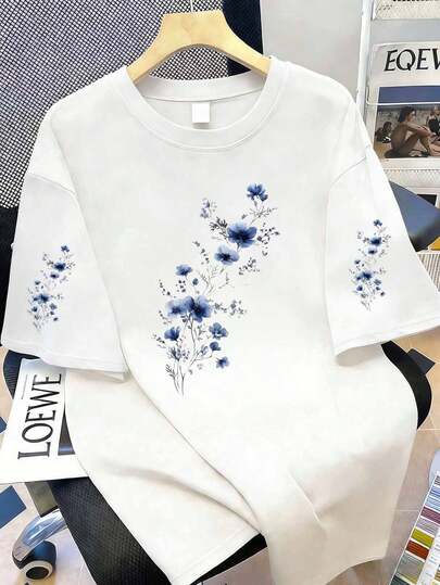 Camiseta de mujer de manga corta con cuello redondo y estampado floral elegante, blanca con flores azules, versátil y casual para todas las estaciones