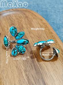 这款复古西部乡村风格的做旧银色仿绿松石花朵戒指，采用美式复古开口设计。戒指以做旧银色为底，镶嵌蓝绿色纹理仿绿松石，组成立体花朵造型，边缘饰以复古铆钉纹理。融合了美式西部/乡村和复古风格，兼具天然石材的质感和做旧金属工艺，散发出粗犷不羁的气息，是西部风格造型的完美点缀。 - 開口松石戒指 - 查看 7