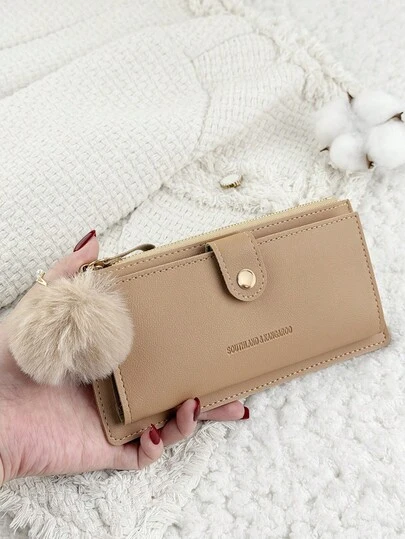 这款卡其色折叠长钱包饰有绒球吊坠，时尚现代，商务气息浓郁，轻薄便携，容量大，可收纳信用卡、身份证、现金等，适合商务休闲场合，是学校、大学、工作、商务通勤、教师节、返校季、假期、办公室周年纪念日、送给爱人、作为生日礼物的理想之选。也适合女性白领、大学生等，是学校宿舍和返校季的理想之选。