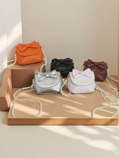 1个女童蝴蝶结PU磁扣简约珍珠链条斜挎包，适合日常四季使用