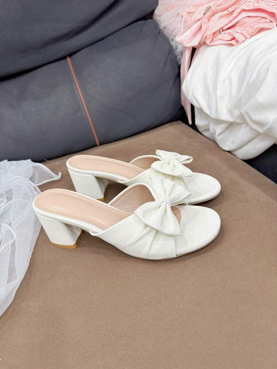 1双白色可爱凉鞋，蝴蝶结褶皱设计，优雅高跟，适合各种场合和通勤。