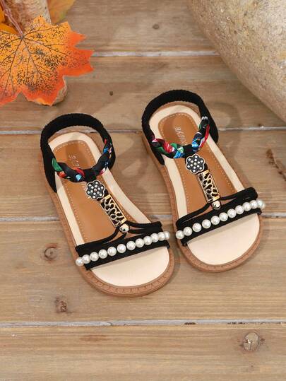 这款最新款夏季儿童珍珠流苏平底凉鞋——黑色设计，是日常出行、校园生活和公园散步的绝佳选择。它们可以轻松搭配各种服装，时尚、休闲又舒适。