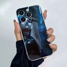 Jinx de Arcane observa las luces azules. Esta elegante funda es compatible con los modelos  17, 16, 15, 14 Pro Max, 13, 12, 11, XR y XS Plus. Fabricada en silicona de vidrio, ofrece protección contra golpes y caídas, además de una sensación superior. Es un regalo ideal para familiares, amigos y seres queridos, y una opción perfecta para Año Nuevo. - transparente - Ver 2