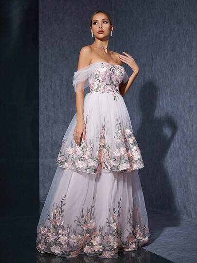 A One-Shoulder Dress With Three-Dimensional Appliques, Pleated Net Fabric, Layered Embroidery, And Lace. It Features A Large Skirt.