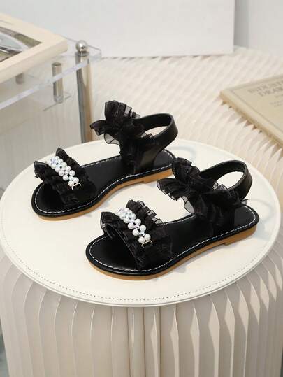 这款最新款夏季儿童褶皱珍珠水钻平底凉鞋——黑色设计，是日常出行、派对活动和商场购物的绝佳选择。它们可以轻松搭配各种服装，时尚、休闲又舒适，是女童凉鞋的理想之选。