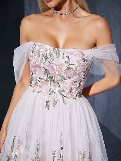 A One-Shoulder Dress With Three-Dimensional Appliques, Pleated Net Fabric, Layered Embroidery, And Lace. It Features A Large Skirt.