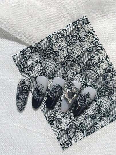 En utsökt retroklistermärke med reliefhantverk, huvudsakligen tillverkad av svart spets, i kombination med ihåliga texturer av blommor och grenar, lämplig för personlig DIY och för att skapa nagelkonst i retro, elegant och lyxig stil.